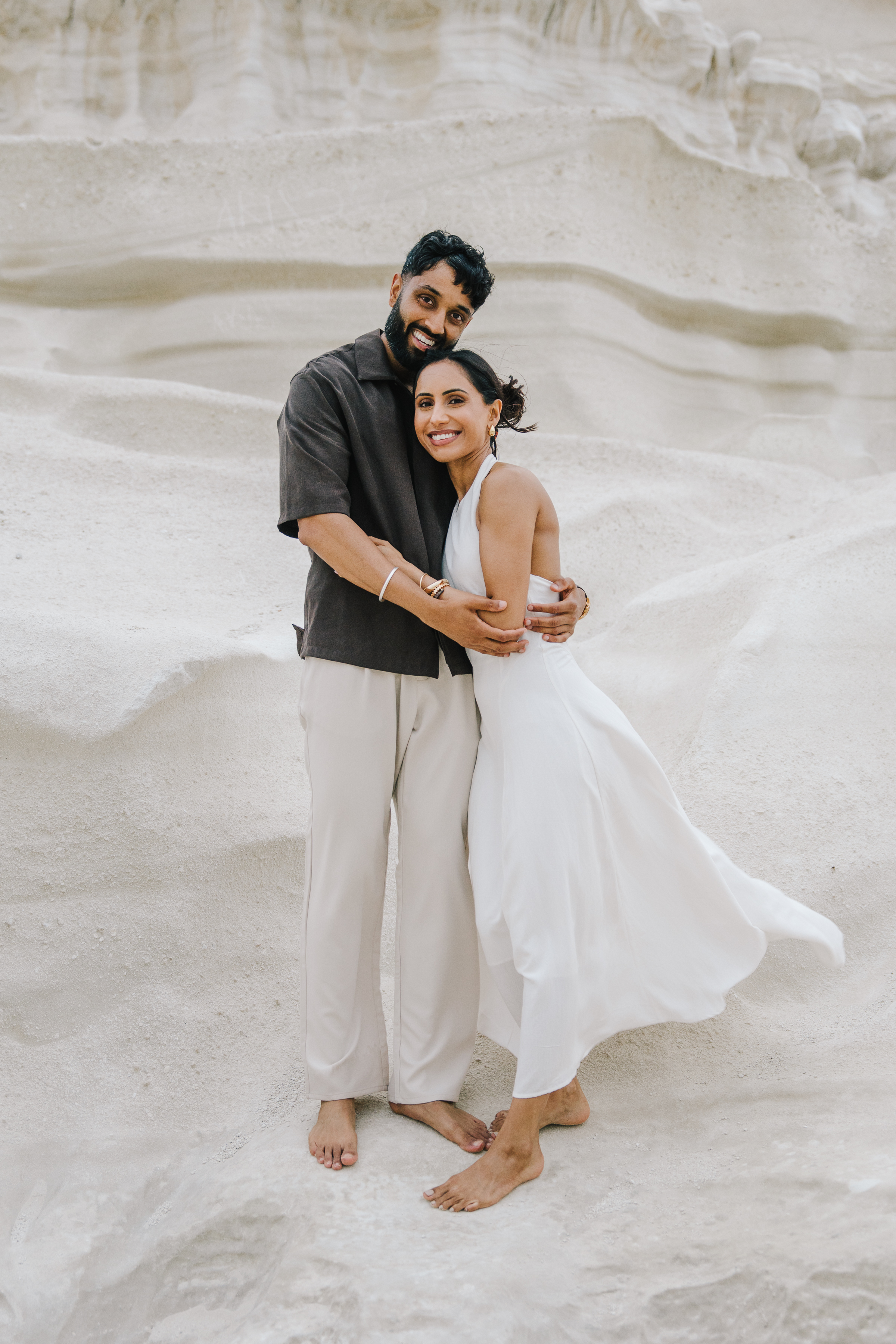 Romantic couple portrait among the white volcanic rocks of Sarakiniko