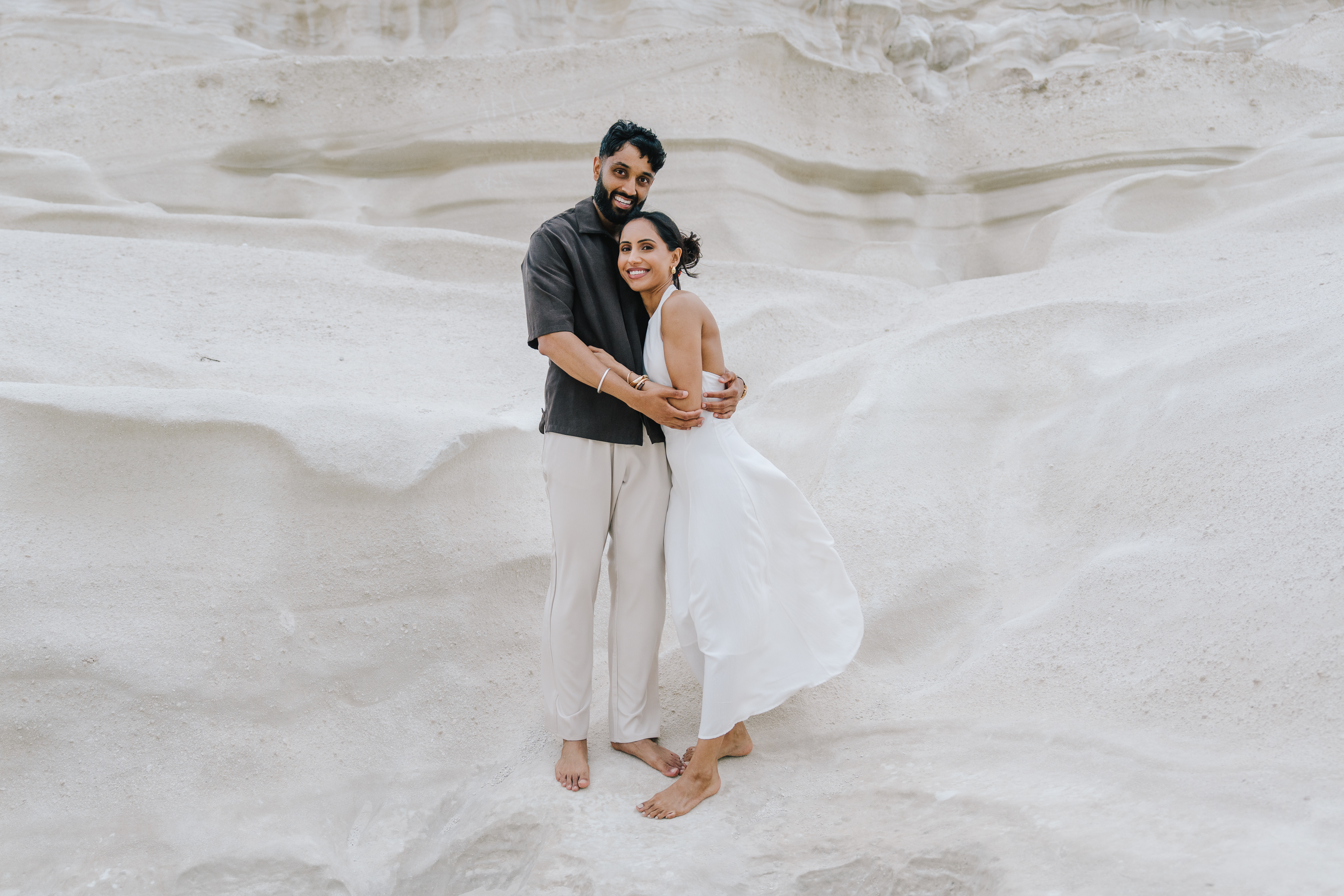 Romantic couple portrait among the white volcanic rocks of Sarakiniko