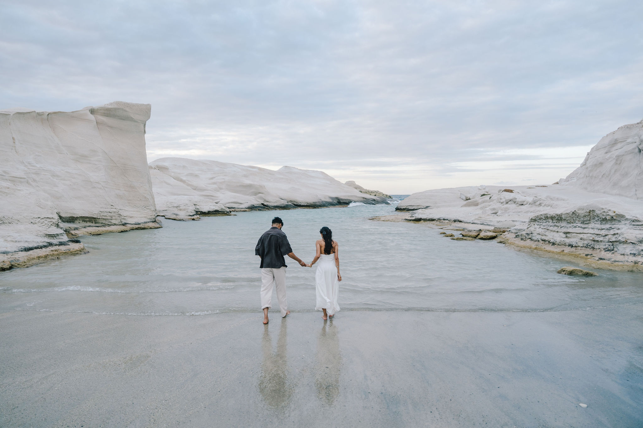 Romantic couple portrait among the white volcanic rocks of Sarakiniko