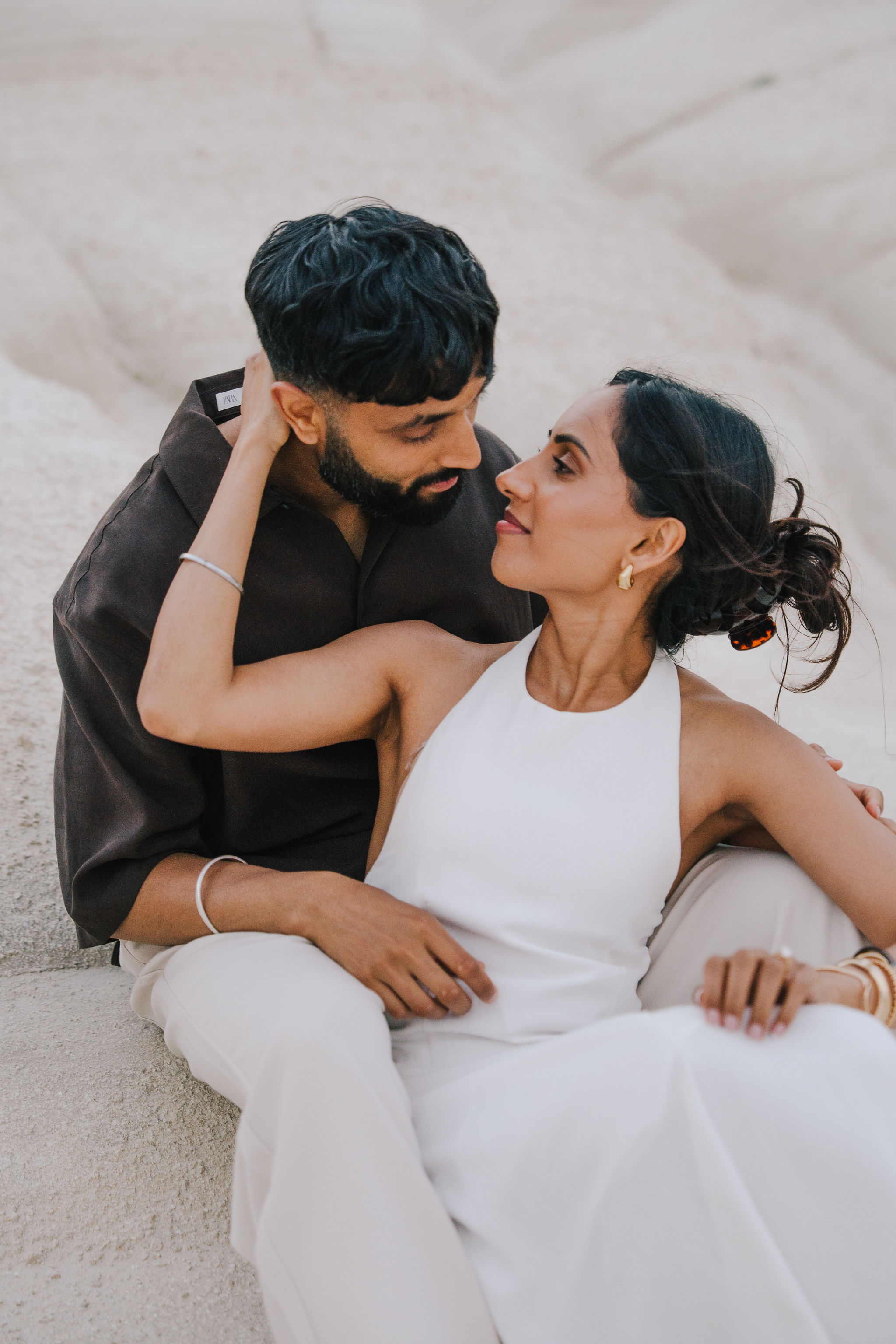 Romantic couple portrait among the white volcanic rocks of Sarakiniko