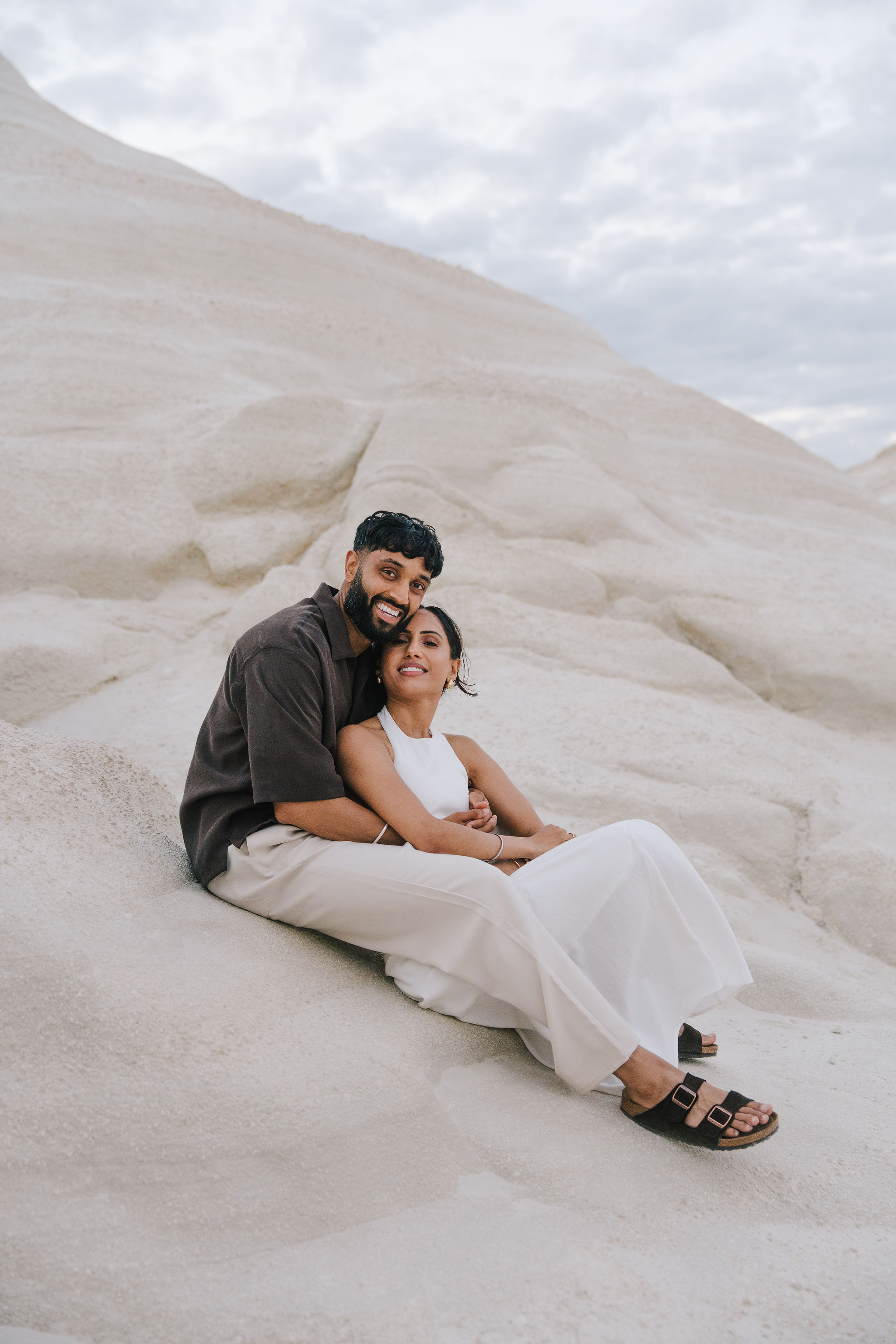 Romantic couple portrait among the white volcanic rocks of Sarakiniko